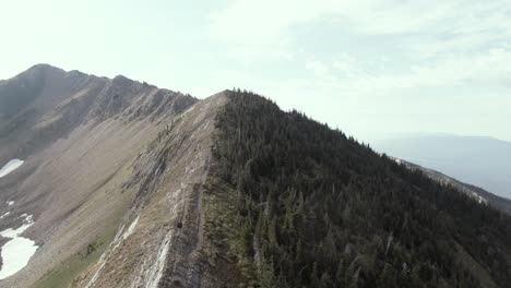 a solo hiker walking the spine of a mountain in montana