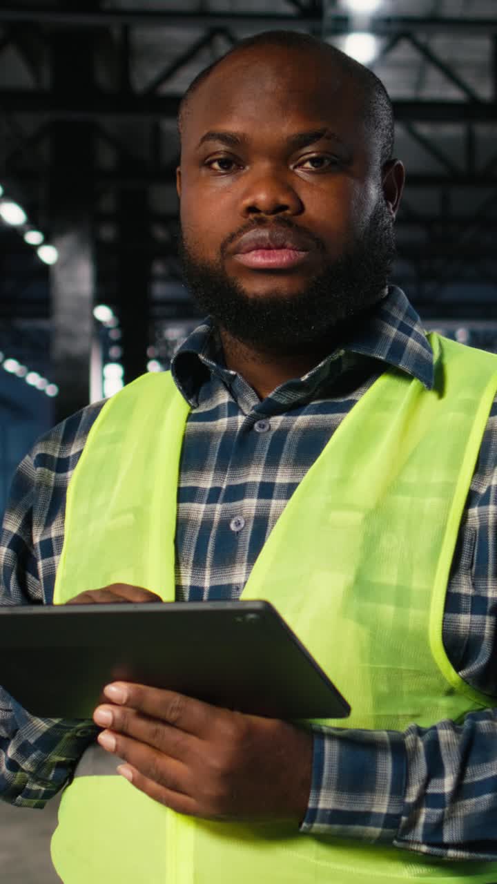 Vertical Video Black industrial employee works beside welding sparks on the factory floor