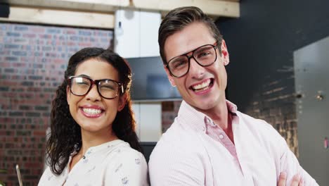 Business-executives-standing-with-arms-crossed-in-office