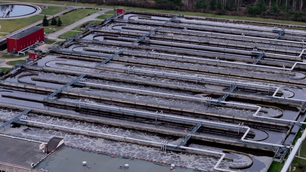 Slow drone of wastewater flowing through filtration systems on cold, cloudy day