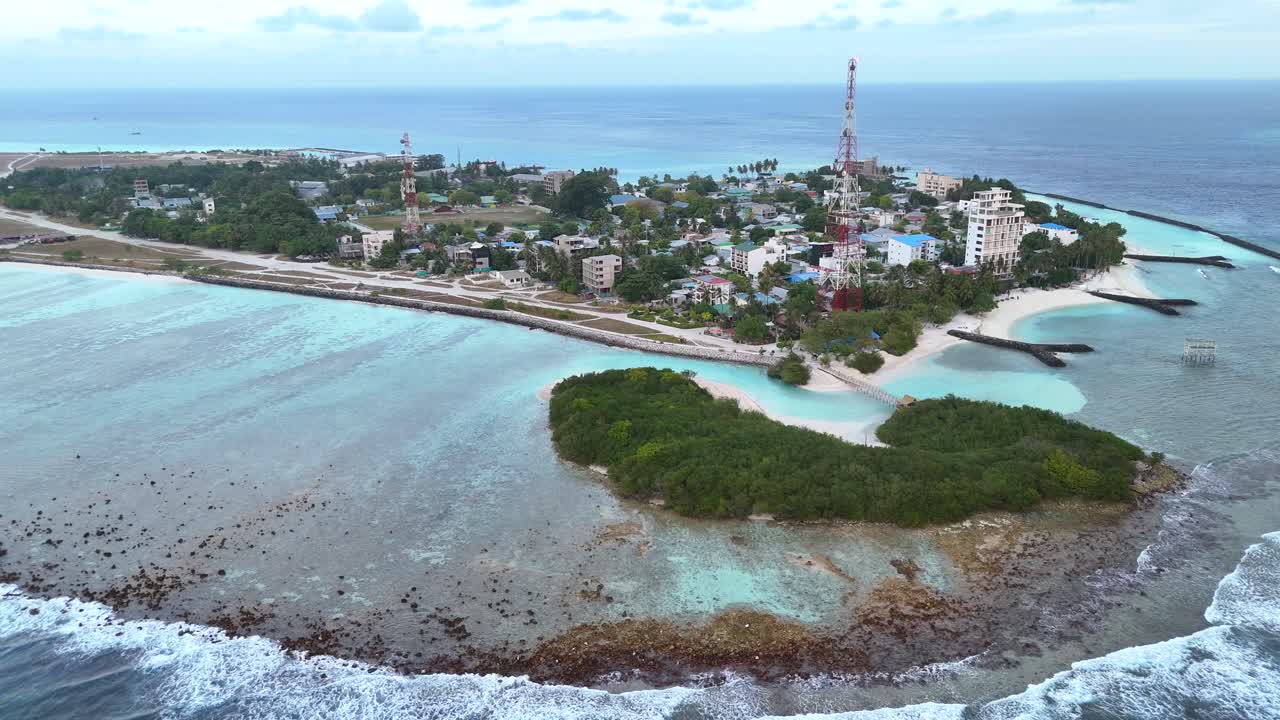 Ripresa aerea con drone Thulusdhoo Maldive isola tropicale esotica remota barriera corallina sabbia bianca acqua turchese.