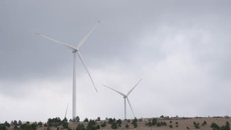 a large wind turbine plant. sustainable and renewable green energy from the wind. turbines arranged on a mountain plateau. windy weather before the storm.