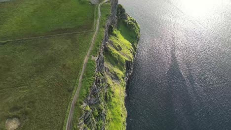 drone shot of the cliffs of moher at sunset, top down over the cliffs and waves