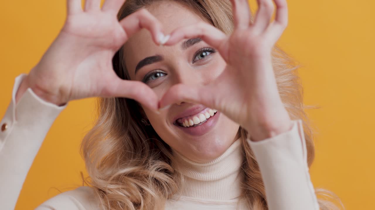 mujer haciendo una forma de corazón con las manos