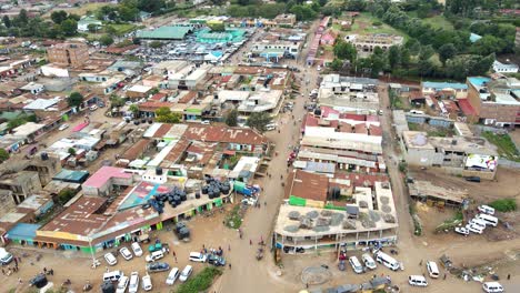 Aerial-view-of-cars-and-people-at-a-Open-Air-Market,-in-Africa---reverse,-drone-shot