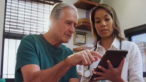 fisioterapeuta y hombre mayor usando tableta digital 4k