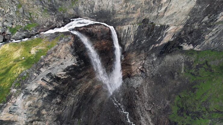 Cascata che cade da alte rocce di una montagna in Norvegia, filmata con un drone.