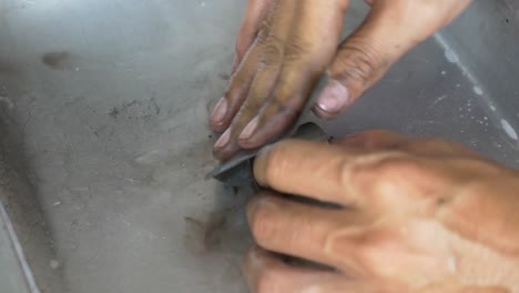 close-up footage of the technician working on motorcycle brake caliper cleaning process