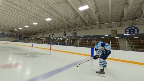 Fpv-Drohne,-Eishockeyspieler-Stick,-Der-Den-Puck-Auf-Der-Eisbahn-In-Der-Halle-Handhabt