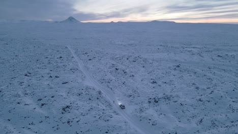 persona explorando el terreno volcánico nevado, la montaña keilir en el fondo
