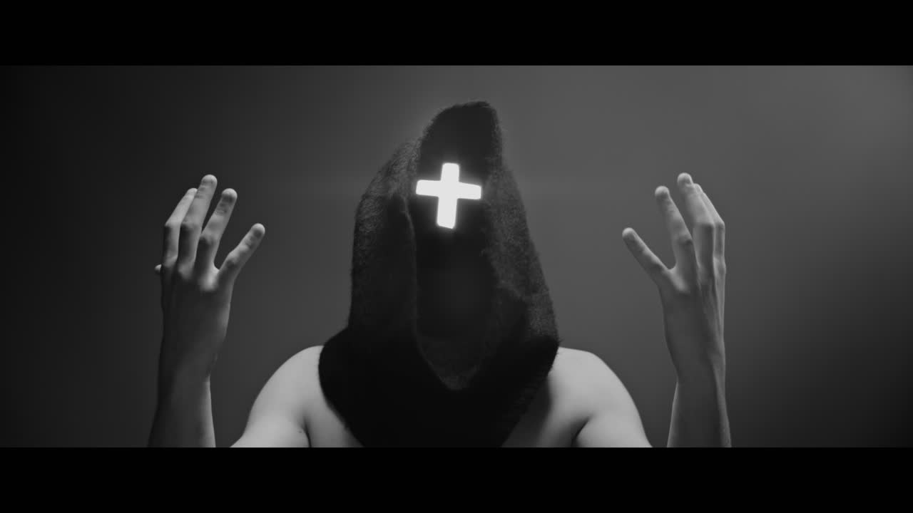 Masked man with cross of light glowing on his face prays
