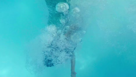 pretty woman in green dress diving in the pool