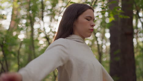 young woman meditating in a forest