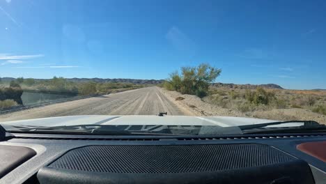 pov conduciendo en una carretera de grava en el área de vida silvestre del lago mittry cerca de yuma az en el desierto de sonora en el suroeste de arizona en un día brillante y soleado