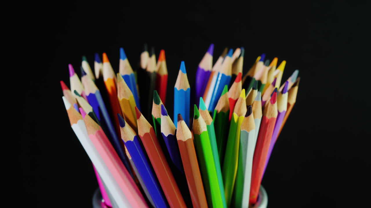 un juego de lápices multicolores sobre un fondo negro