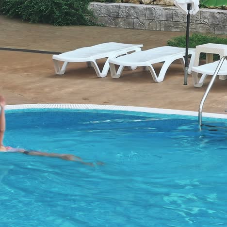 una joven sensual relajándose en la piscina.