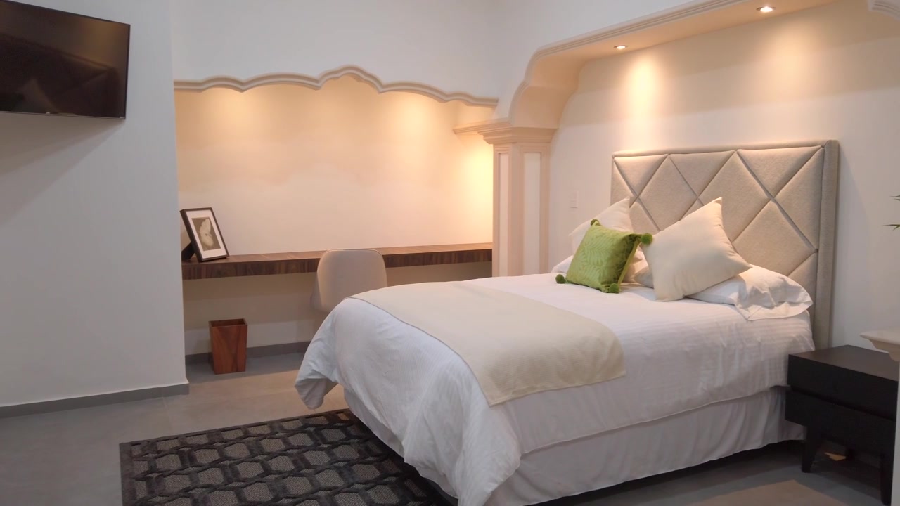 Luksuriøst hotelværelse med polstret seng, indbygget arbejdsplads, fjernsyn, varm stemningsbelysning og elegante detaljer. Eksklusiv gæstfrihed og ejendomsindretning
