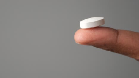 white pill on finger