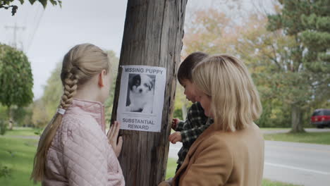 a woman with children pastes ads about a missing puppy