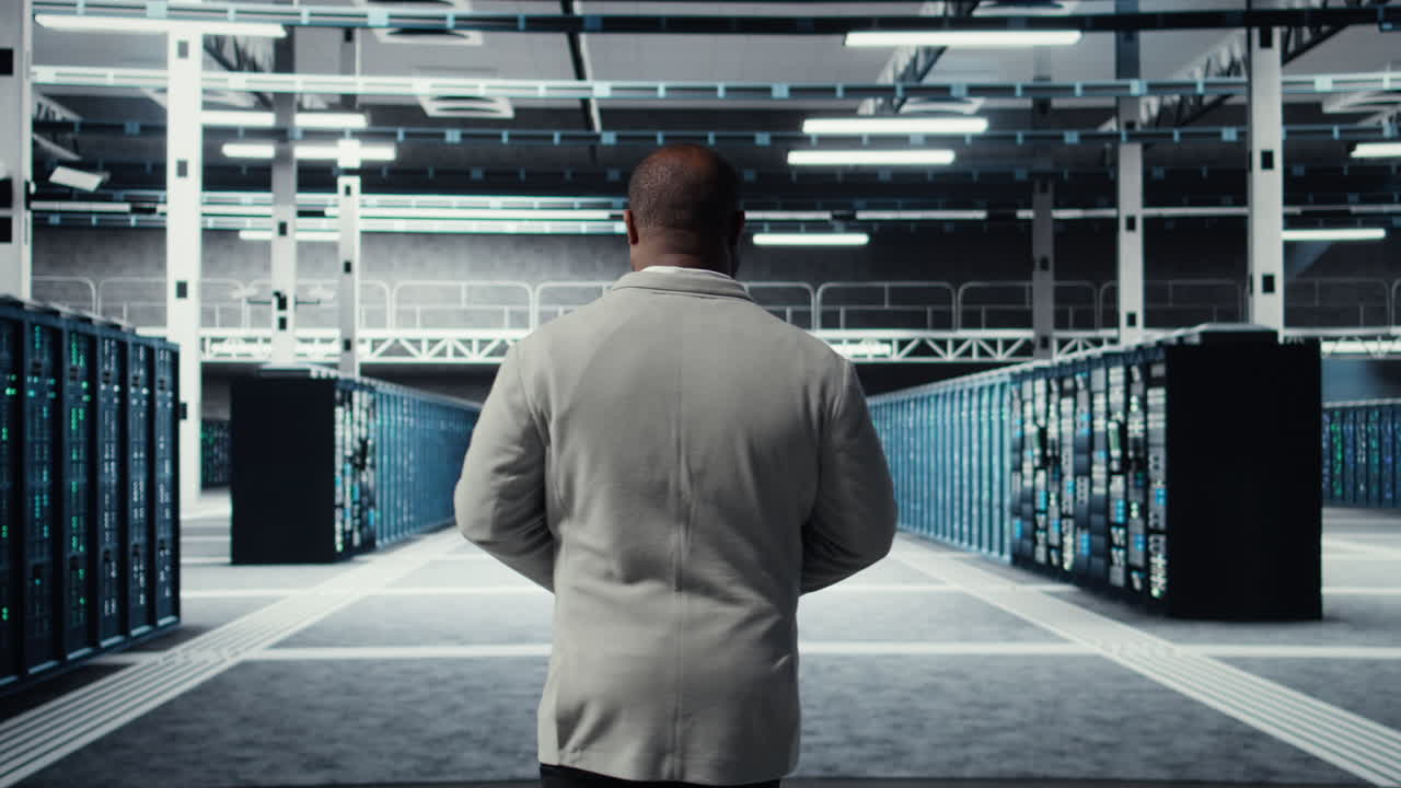 Vertical video System administrator walking in data center with rows of rackmounts