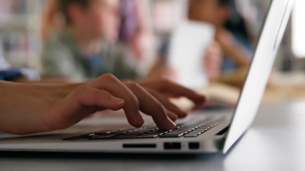 un estudiante de la sección media usando una computadora portátil 4k