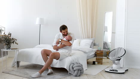 Proud-father-holding-his-newborn-baby-daughter-in-his-at-home
