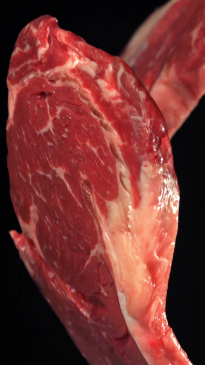 Close-up of Fresh Raw Beef Steaks on Black Background