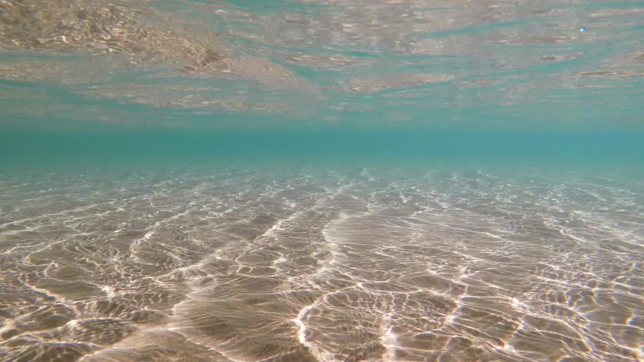 água do mar azul refrações ensolaradas em fundo arenoso, fundo pronto para loop subaquático