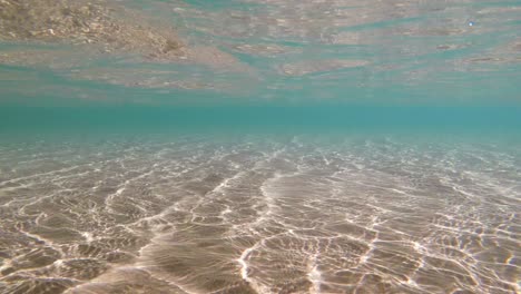 refracciones azules de agua de mar soleadas en el fondo arenoso, fondo listo para bucles submarinos