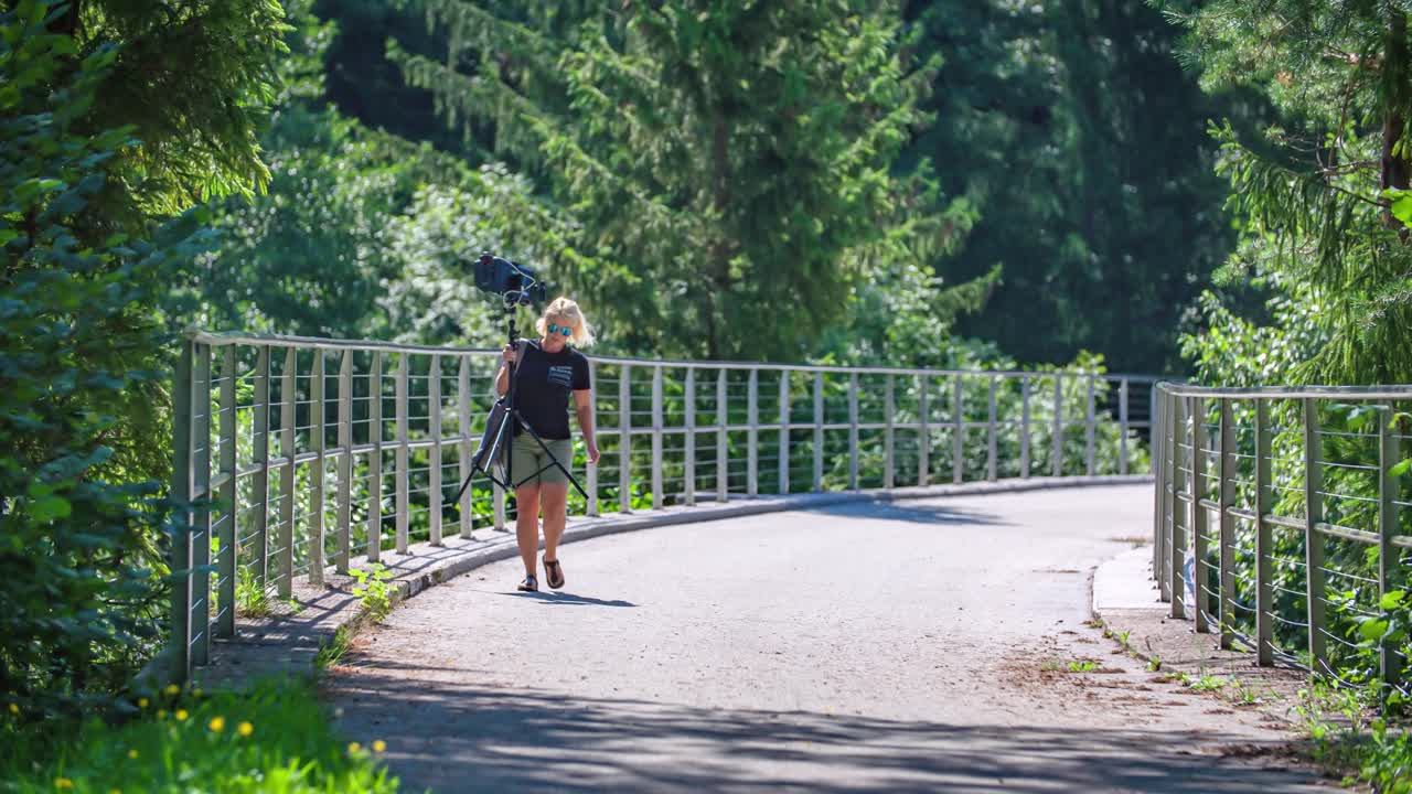 자연 한가운데 사진 장비를 들고 아름다운 금발의 여자