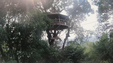 pov of male ziplining towards a treehouse during the gibbon experience in laos