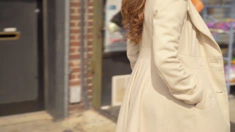 woman walking through the street wearing a coat