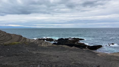 Iceland-dark-color-volcanic-sand-beach,-pan-right-view