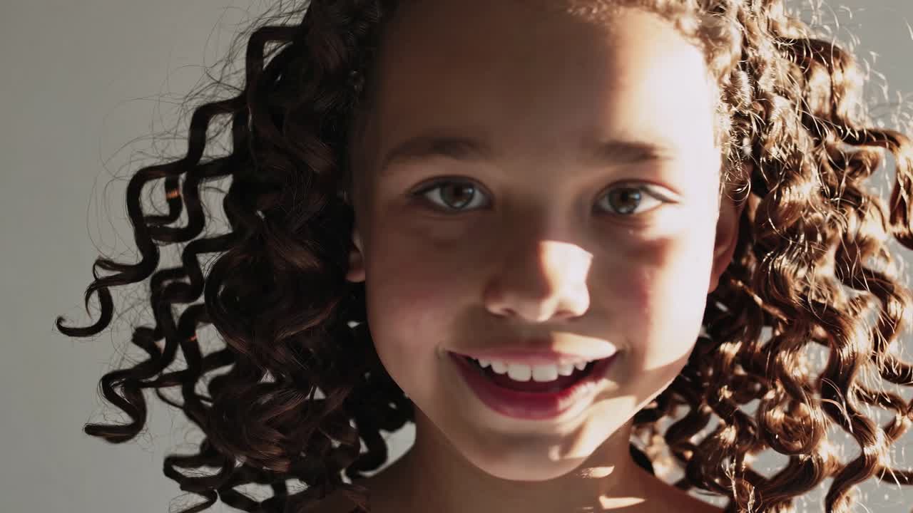 retrato de una chica sonriente de cabello rizado