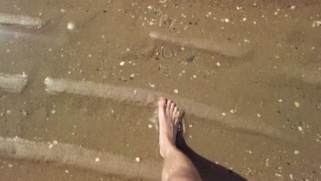 Closeup-of-feet-while-walking-on-sand-of-norther-sea-shoreline-in-Zeeland,-Netherlands---4k60