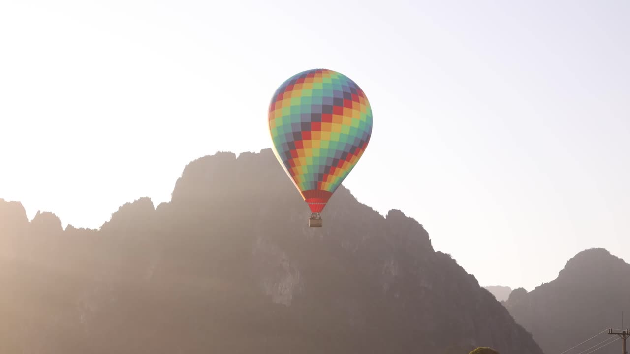 colorful hot air balloon floating over mountain ridges in Vang Vieng, the adventure capital of Laos