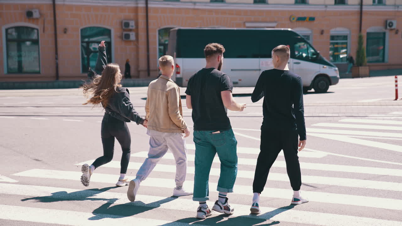 Happy friends walking through the road. Good looking guys spending time with friends in city in a sunny day. Young people enjoying the time together