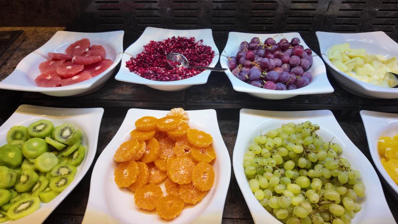 Utvalg av fersk oppskåret frukt på en buffetutstilling.