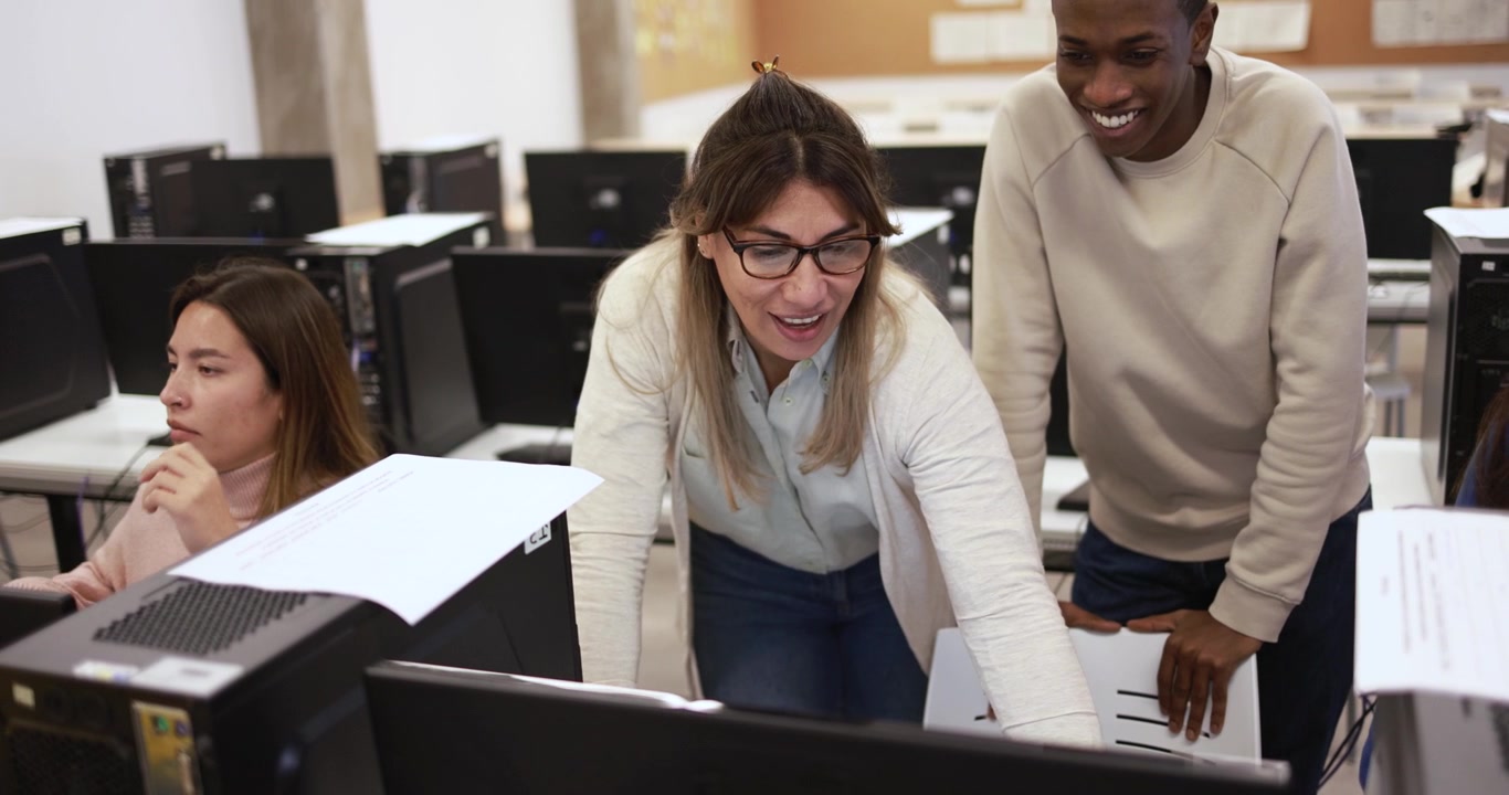 Teacher Assisting Students in Computer Lab Classroom