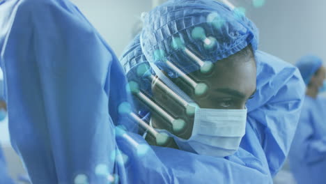 animación de la cadena de adn sobre diversos médicos con máscaras faciales durante la cirugía