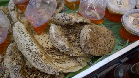 raw honey nest on counter for sale at thailand street food market