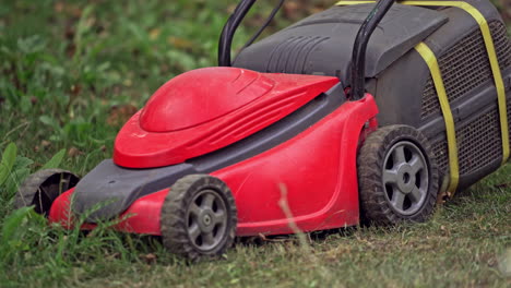 lawn mower on green grass. close up view of man mowing the grass