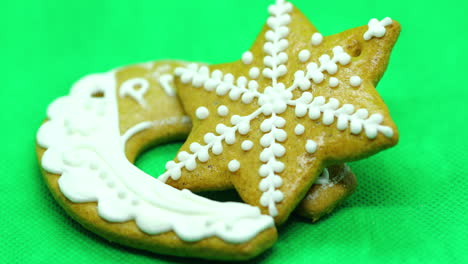 pastel de pan de jengibre con adornos blancos en la parte superior en forma de un dulce de navidad inclinado sobre un fondo verde