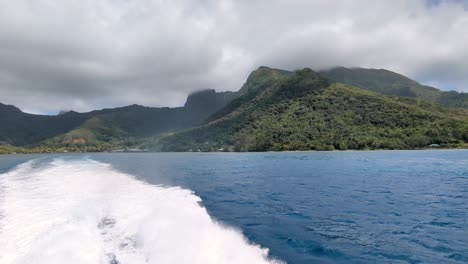 leaving the tropical island of moorea french polynesia on ferry boat with views of rugged mountainous terrain and ocean