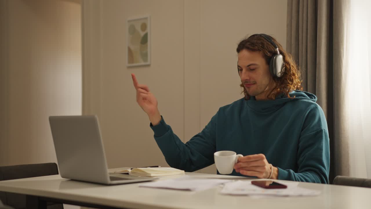 Man working remotely with laptop, coffee, and headphones