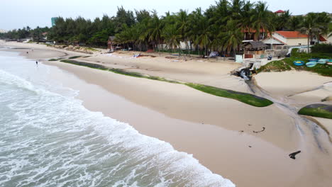 ocean waves destroying tropical sandy beach by erosion, aerial drone view