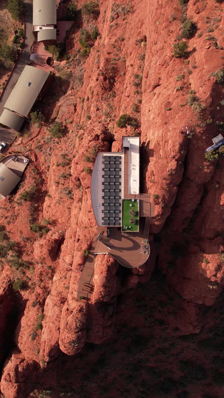 vista aérea vertical de arriba hacia abajo de una casa futurista con paneles solares en la cima de un acantilado en el paisaje desértico de sedona, arizona, estados unidos