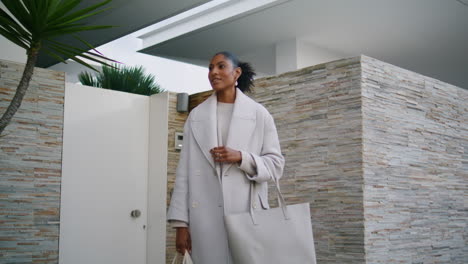 Woman-posing-house-door-closeup.-Smiling-african-american-holding-keys-looking