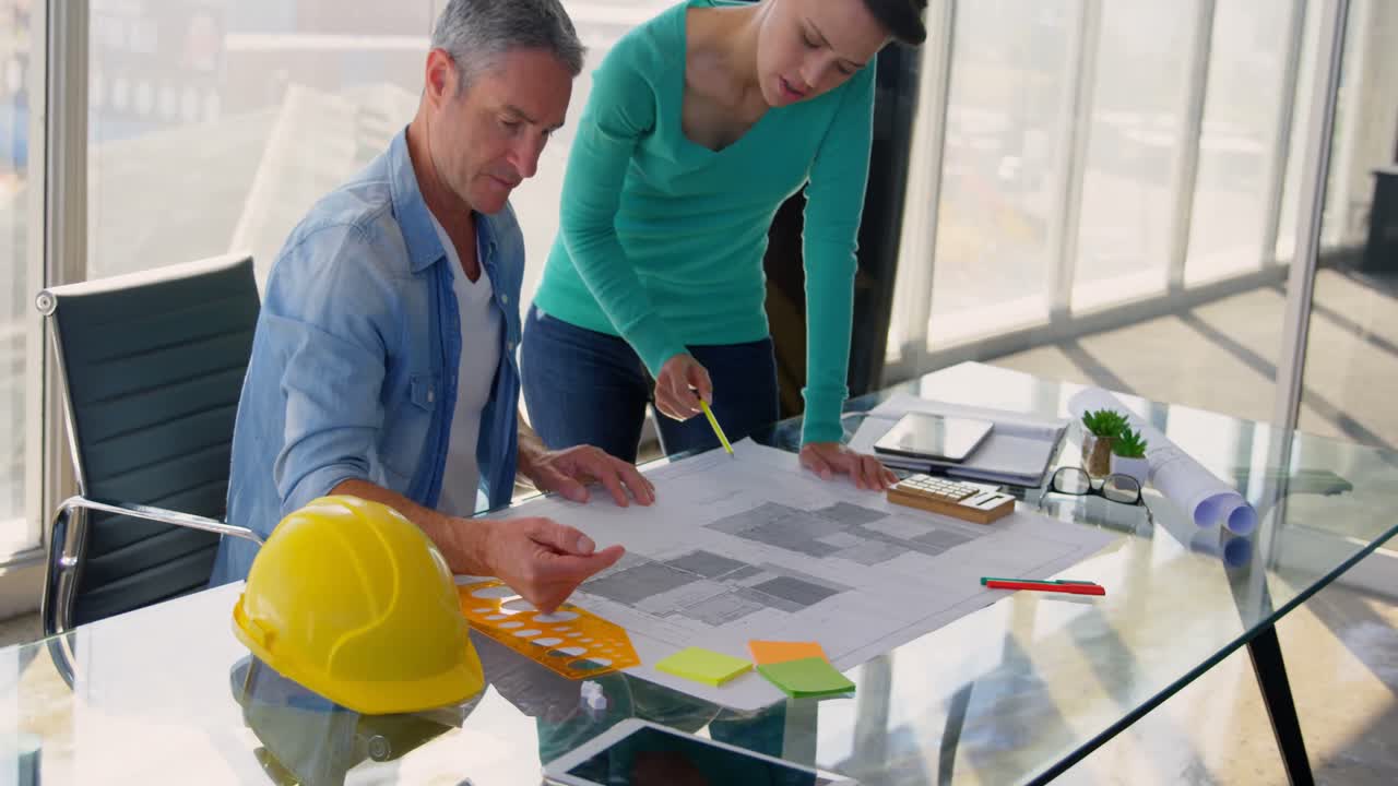 vista frontal de la gente de negocios caucásica discutiendo sobre el plano en la oficina 4k