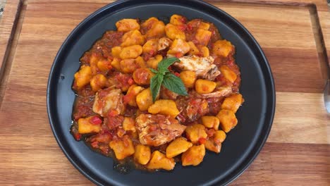 homemade pumpkin gnocchi tossed in a savory tomato sauce with tender chicken - close up